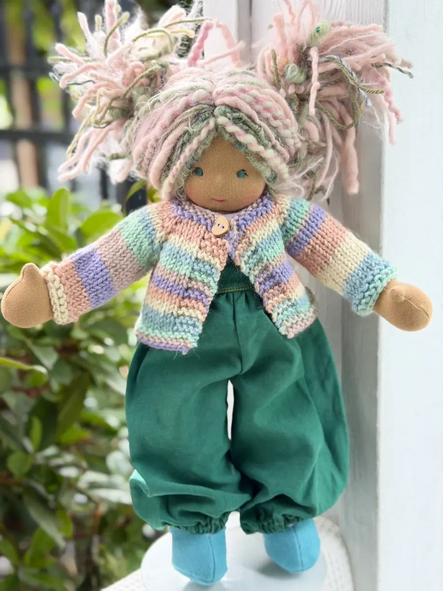 Bamboletta cloth doll with pink and green yarn hair and a striped cardigan