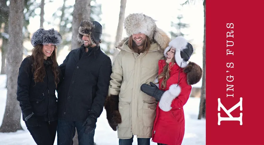 Four people outdoors wearing Kings Furs hats and winter accessories