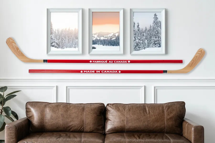 Two red-shaft wood hockey sticks marked Made in Canada