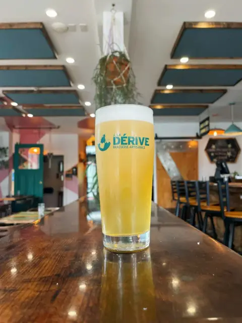 A glass of À La Dérive beer on the bar of its Gatineau pub