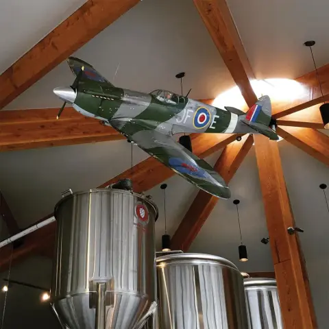 Brewing tanks under a model fighter plane at Ace Brewing