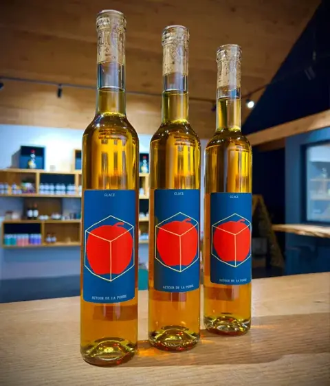 Three bottles of Autour de la pomme ice cider on the tasting-room counter