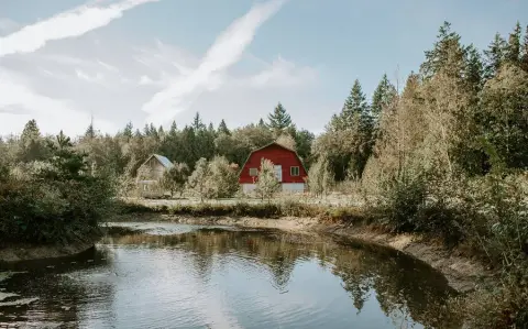 The pond and red barn on the Banditry cider farm in Gibsons