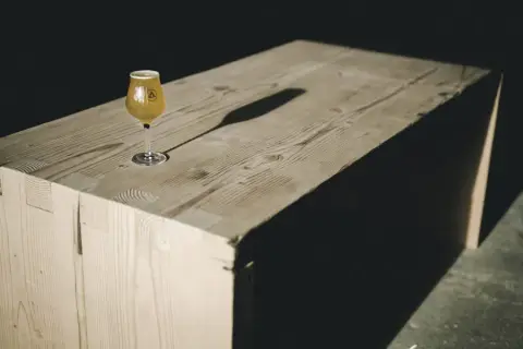 A glass of Bannerman beer on a wooden bench
