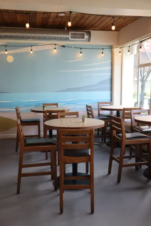 Brewing August taproom with wooden tables and a seaside mural