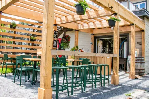 Wooden pergola terrace in front of the Camp de Base brewhouse