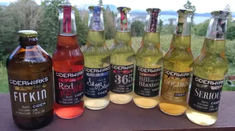 A row of Ciderworks bottles lined up on a railing