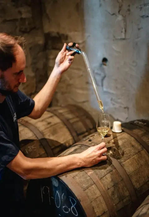 Drawing a sample of cider from an oak barrel at Cidrerie Lacroix