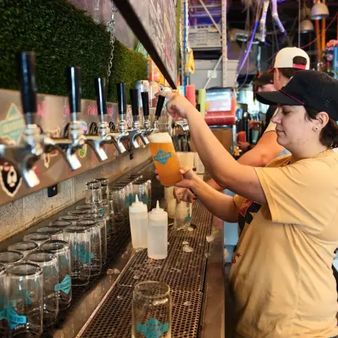 A bartender pouring a pint of draft beer at Cold Garden