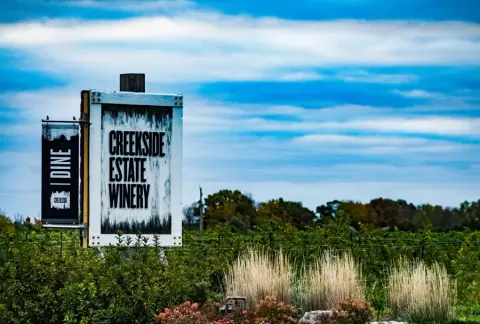 The Creekside Estate Winery sign in front of the vineyard