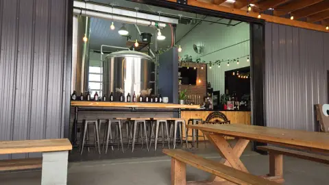 Taproom and patio with brewing tanks behind the bar