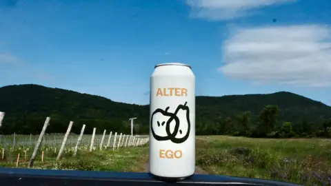 A can of Alter Ego, a pear and McIntosh cider