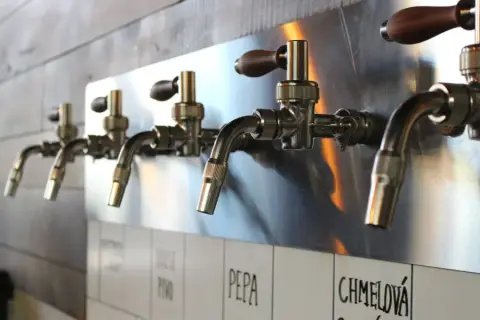 Beer taps on a stainless steel wall at Godspeed