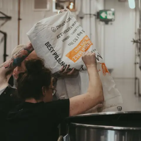 Brewers adding malt to the mash at Good Neighbour Brewing
