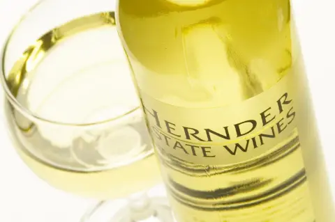 A bottle of Hernder Estate Wines white wine beside a filled glass