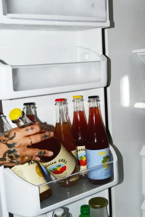 A row of Ibride cider bottles in a refrigerator door