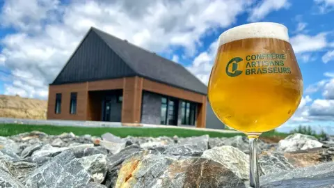 La Confrérie brewery building in Windsor with a glass of beer
