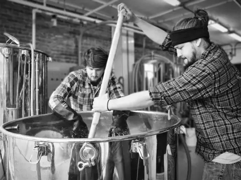 Two brewers stirring the mash at the Lagabière brewery
