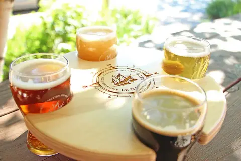 Tasting flight of Le Naufrageur beers on a branded wooden paddle