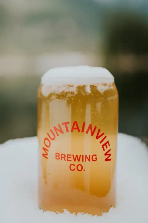 A Mountainview Brewing can glass of beer set in snow