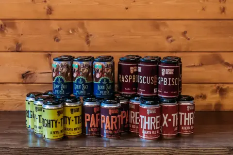 Stacked cans of Kickin' Back Pilsner and Alberta ales