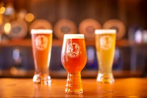 Three Radium Brewing beers in branded glasses on the taproom bar