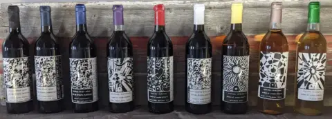 A row of Reveresque fruit wine bottles