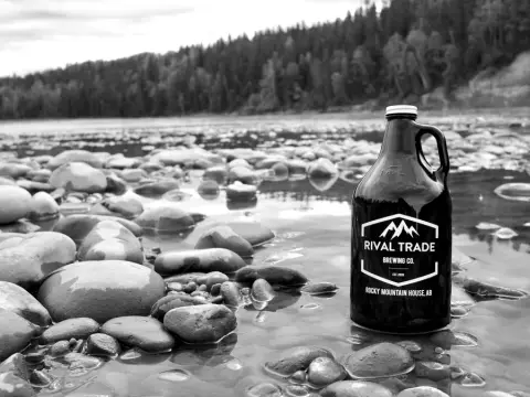 A Rival Trade growler standing in a shallow river