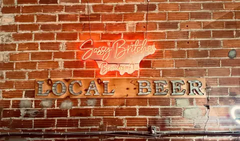 A flight of Sassy Britches craft beers on a wooden paddle at the bar