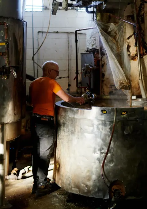 A brewer working the mash tun at Storm Brewing on Commercial Drive