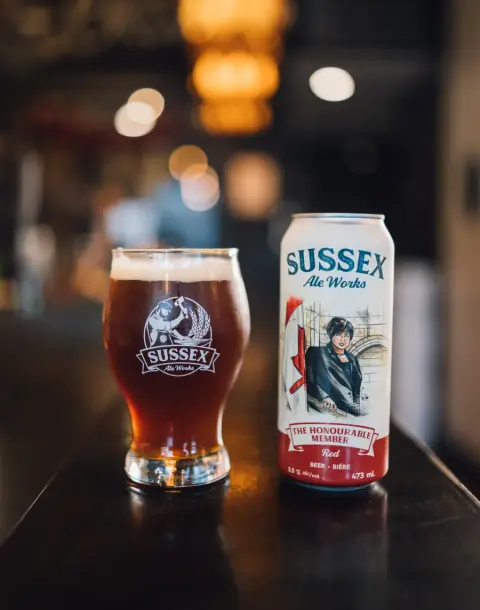 Honourable Member Red Ale in a glass beside its can
