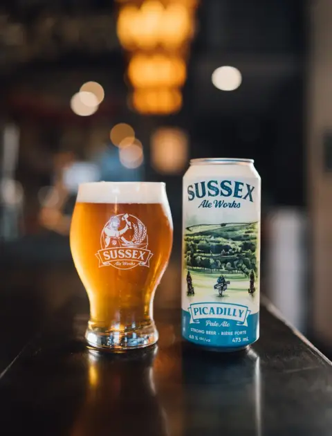 Picadilly Pale Ale in a glass beside its can
