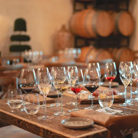 Wine glasses set for a tasting in front of oak barrels in the Foreign Affair cellar