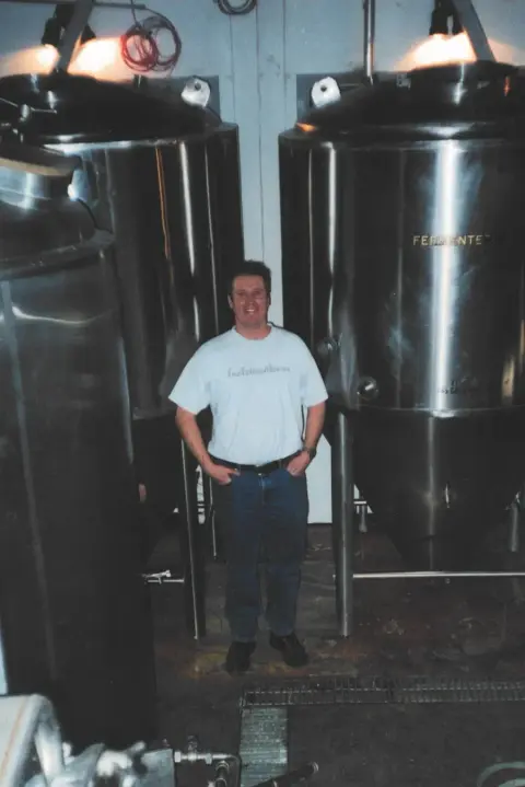 Founder Niall Fraser between fermenters in the early Grizzly Paw brewhouse