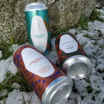 Three cans of Tinhouse beer outdoors