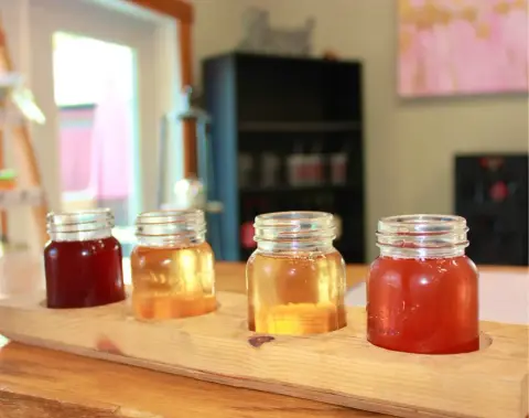 A tasting flight of four Tony's hard ciders on a wooden board