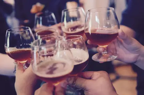 A group of people are toasting with wine glasses.